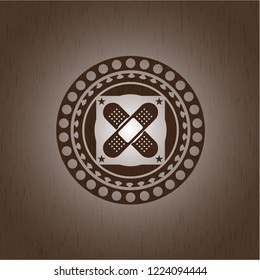 crossed bandage plaster icon inside retro style wooden emblem