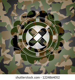crossed bandage plaster icon inside camo emblem