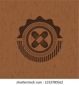crossed bandage plaster icon inside wooden emblem. Retro