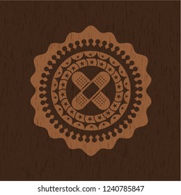 crossed bandage plaster icon inside wooden emblem. Vintage.