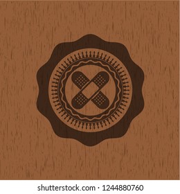 crossed bandage plaster icon inside realistic wood emblem