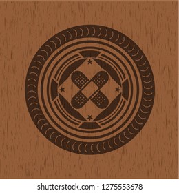crossed bandage plaster icon inside realistic wooden emblem