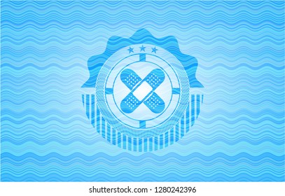 crossed bandage plaster icon inside sky blue water wave badge background.