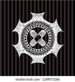 crossed bandage plaster icon inside silvery emblem or badge