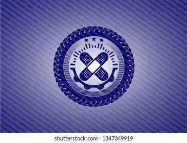 crossed bandage plaster icon inside emblem with jean background