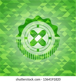crossed bandage plaster icon inside green emblem with mosaic ecological style background