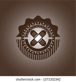 crossed bandage plaster icon inside retro style wooden emblem