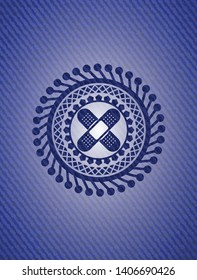 crossed bandage plaster icon inside badge with denim background