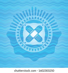 crossed bandage plaster icon inside sky blue water badge background.