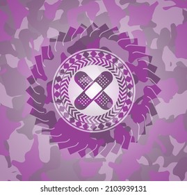 crossed bandage plaster icon on pink and purple camouflage texture. 