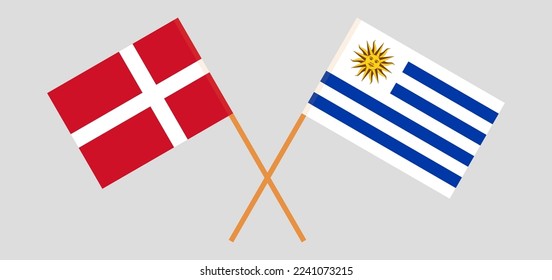 Crossed flags of Denmark and Uruguay. Official colors. Correct proportion. Vector illustration
