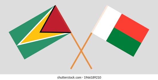 Crossed flags of Guyana and Madagascar. Official colors. Correct proportion