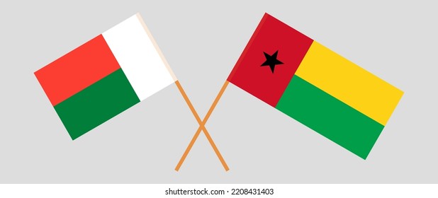 Crossed flags of Madagascar and Guinea-Bissau. Official colors. Correct proportion. Vector illustration
