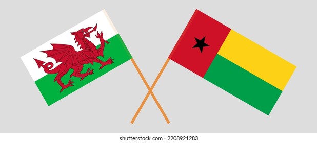 Crossed flags of Wales and Guinea-Bissau. Official colors. Correct proportion. Vector illustration
