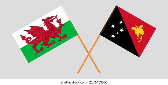 Crossed flags of Wales and Papua New Guinea. Official colors. Correct proportion. Vector illustration
