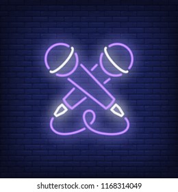 Crossed microphones neon sign. Luminous signboard with stage equipment. Night bright advertisement. Vector illustration in neon style for karaoke, entertainment