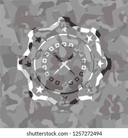 crossed swords icon inside grey camouflaged emblem