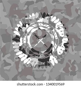 crossed swords icon inside grey camo emblem