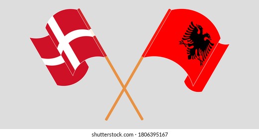 Crossed and waving flags of Albania and Denmark