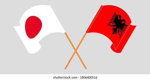 Crossed and waving flags of Albania and Japan