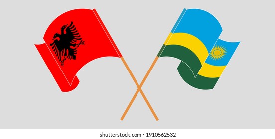Crossed and waving flags of Albania and Rwanda