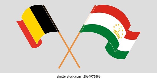 Crossed and waving flags of Belgium and Tajikistan