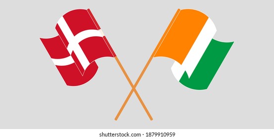 Crossed and waving flags of Denmark and Republic of Ivory Coast