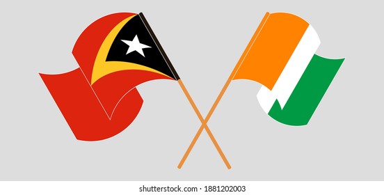 Crossed and waving flags of East Timor and Republic of Ivory Coast