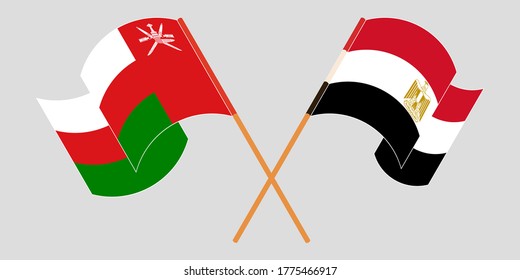 Crossed and waving flags of Egypt and Oman