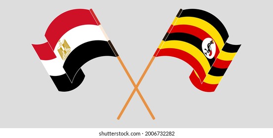 Crossed and waving flags of Egypt and Uganda