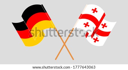 Crossed and waving flags of Georgia and Germany