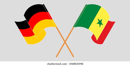 Crossed and waving flags of Germany and Senegal