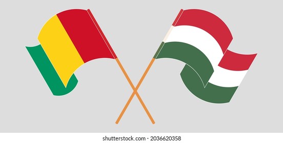 Crossed and waving flags of Guinea and Hungary