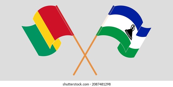 Crossed and waving flags of Guinea and Kingdom of Lesotho. Vector illustration
