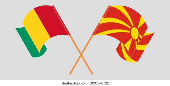 Crossed and waving flags of Guinea and North Macedonia