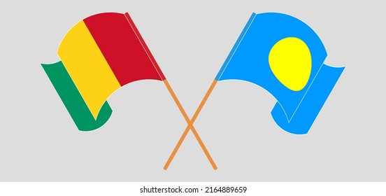 Crossed and waving flags of Guinea and Palau. Vector illustration
