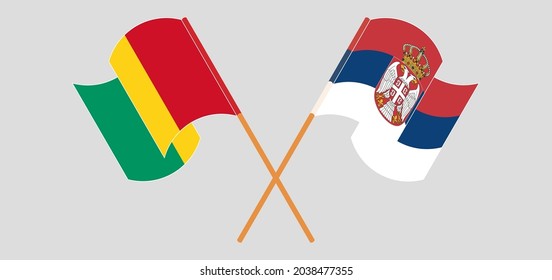 Crossed and waving flags of Guinea and Serbia