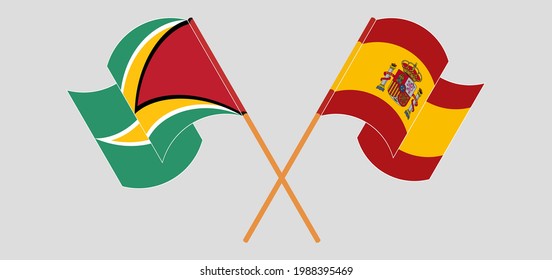 Banderas cruzadas y ondeando banderas de Guyana y España
