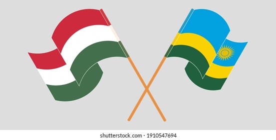 Crossed and waving flags of Hungary and Rwanda