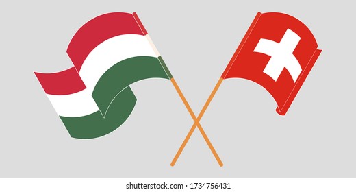 Crossed and waving flags of Hungary and Switzerland