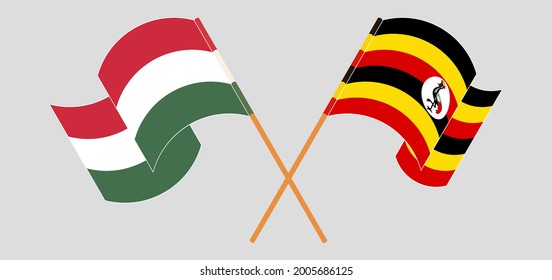 Crossed and waving flags of Hungary and Uganda