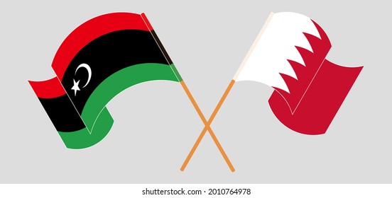 Crossed and waving flags of Libya and Bahrain