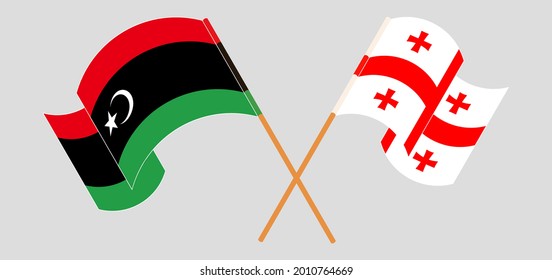 Crossed and waving flags of Libya and Georgia