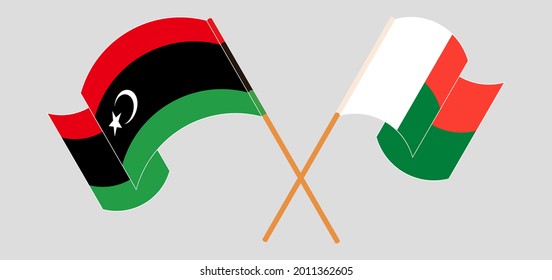 Crossed and waving flags of Libya and Madagascar