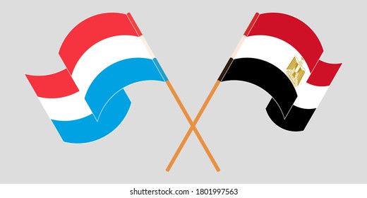 Crossed and waving flags of Luxembourg and Egypt