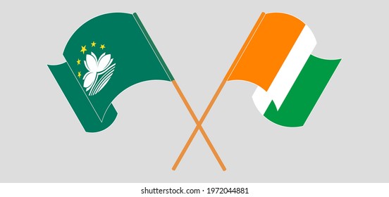 Crossed and waving flags of Macau and Republic of Ivory Coast