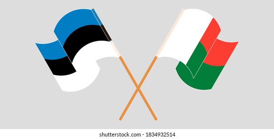 Crossed and waving flags of Madagascar and Estonia