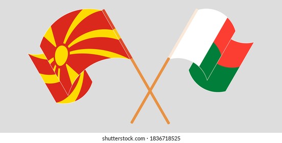 Crossed and waving flags of Madagascar and North Macedonia