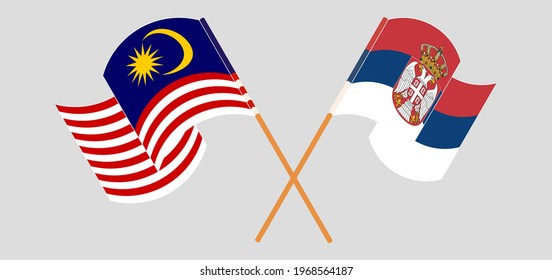 Crossed and waving flags of Malaysia and Serbia