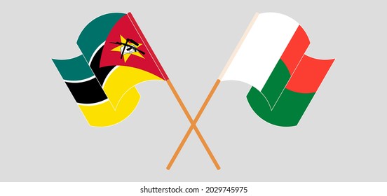 Crossed and waving flags of Mozambique and Madagascar